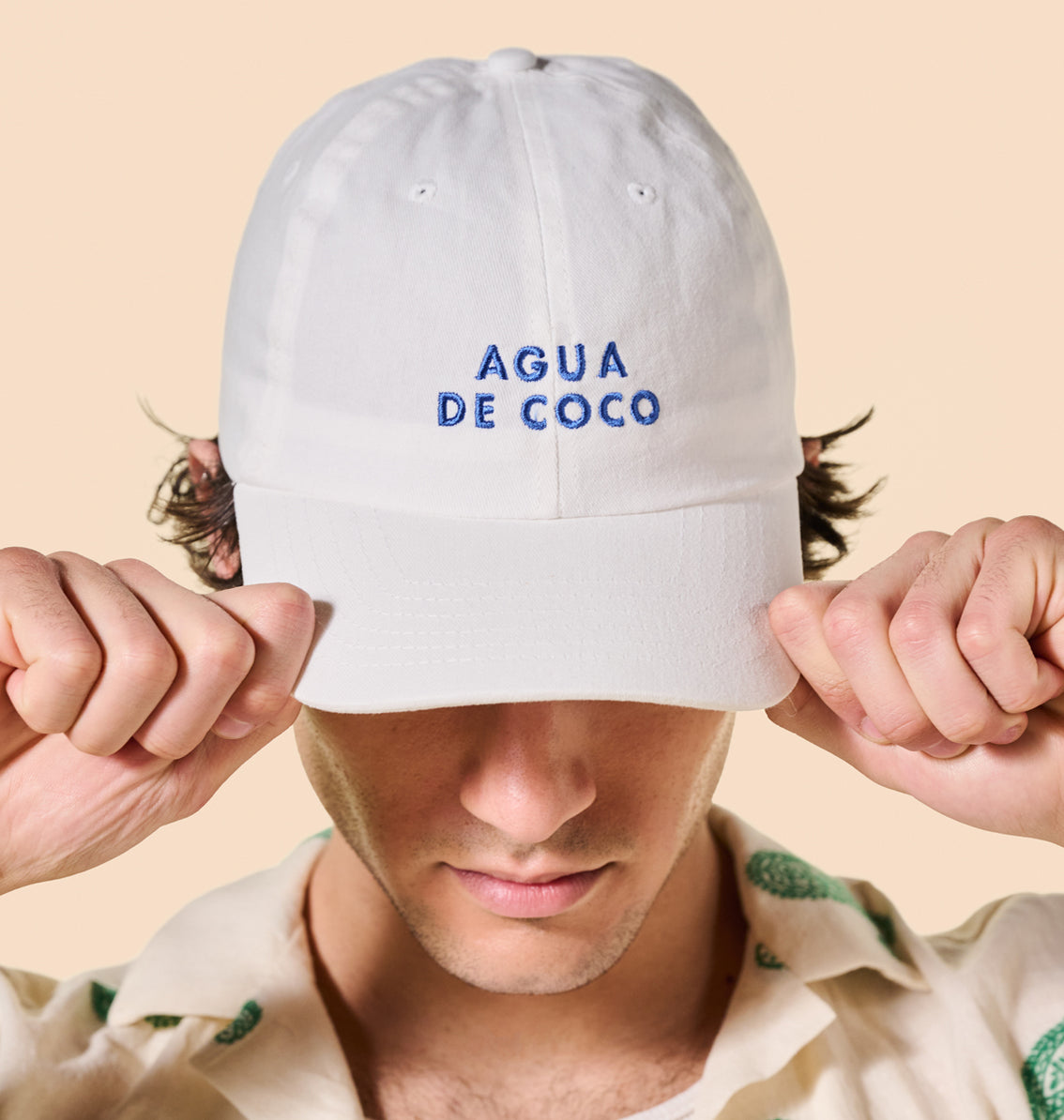 A person wearing a Agua de Coco Baseball Cap by Vita Coco.