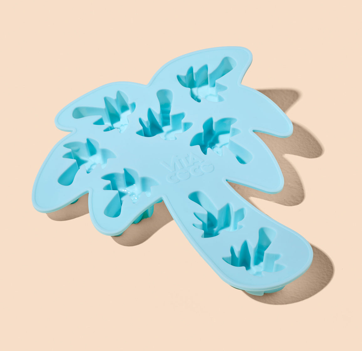 A blue Palm Tree Ice Tray with a Vita Coco-shaped ice.